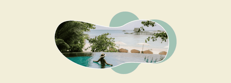 Pinterest for business inspiration: a woman in a sun hat relaxes in an infinity pool overlooking a tropical beach with parasols, sun loungers and a wooden jetty.